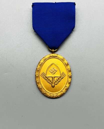 A WW2 German RAD Long Service Medal 1st Class 25 Years constructed in bronze with gilt finish with blue ribbon, oval shaped. The obverse of the medal depicts the the RAD logo in mint condition.