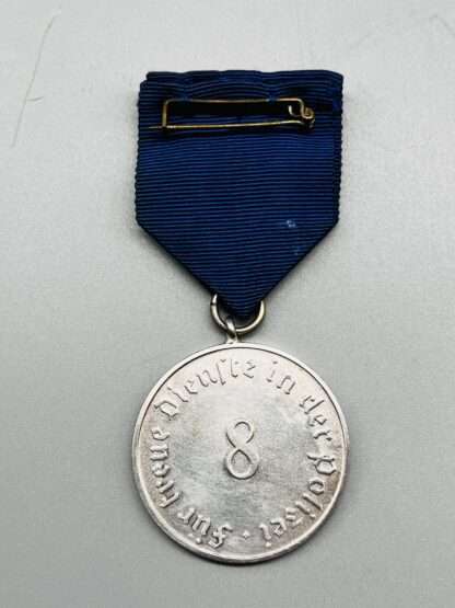 A WW2 German Police Long Service Medal 8 Years, constructed in silvered tombac with period blue ribbon with 8 embossed in the centre.