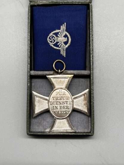 A reverse image of WW2 German Police Long Service Medal 18 Years, constructed in silvered tombac with a period blue ribbon embroidered with police insignia, placed within presentation case lined in grey felt.