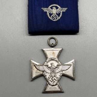 A WW2 German Police Long Service Medal 18 Years, constructed in silvered tombac with a period blue ribbon embroidered with police insignia with police emblem embossed in the centre.