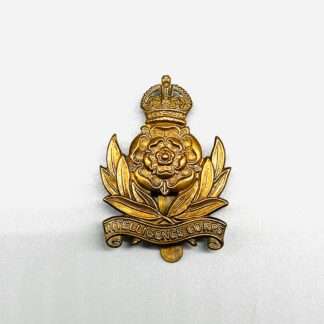 A Intelligence Corps Cap Badge, constructed in brass. The badge depicts a rose in the centre surmounted by an imperial King's crown, between twin sprays of laurel with a scroll below bearing the inscription Intelligence Corps.