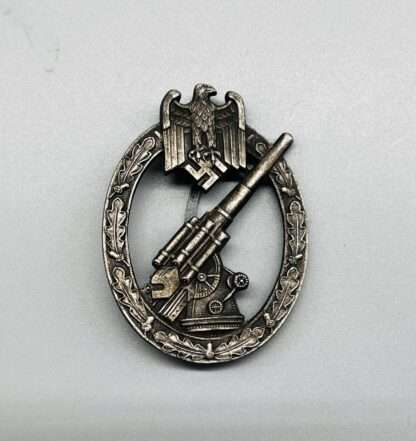 A Heer Flak Badge by Förster & Barth, which depicts a outstretched eagle with a swastika in their talons, with a 88 flak gun in the centre surround by an oak leaf wreath.