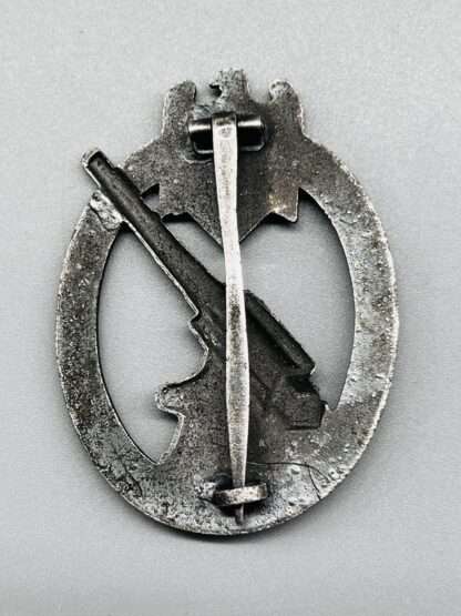 A reverse photo of Heer Flak Badge by Förster & Barth, unmarked with sheet metal barrel hinge, and a vertical pin that goes thick to thin and thick.