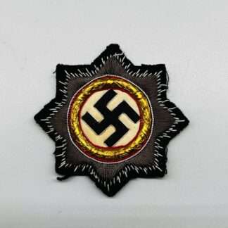 A WW2 Panzer cloth German cross in gold, on black backing cloth.