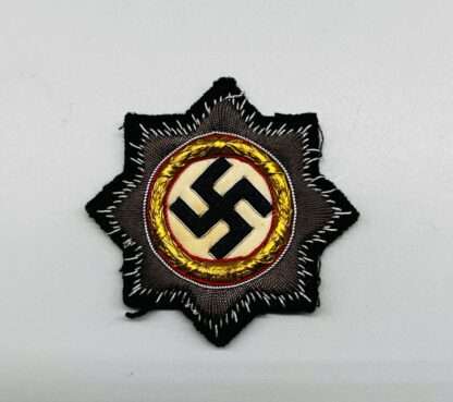 A WW2 Panzer cloth German cross in gold, on black backing cloth.