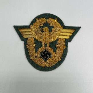 A WW2 German Polizei General Officer Sleeve Eagle Badge, hand embroidered in gold bullion thread on field green wool backing.