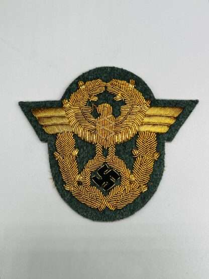 A WW2 German Polizei General Officer Sleeve Eagle Badge, hand embroidered in gold bullion thread on field green wool backing.