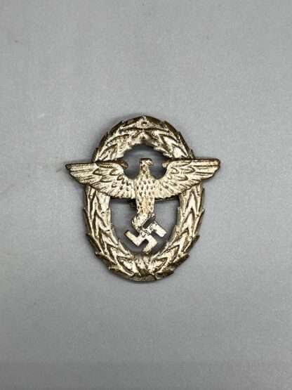 A Police Officer's Visor Cap Insignia 1st Pattern, die-stamped silvered aluminum