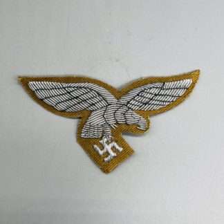 A Luftwaffe Officer's Tropical Breast Eagle,  hand-embroidered in silver bullion on tan backing.