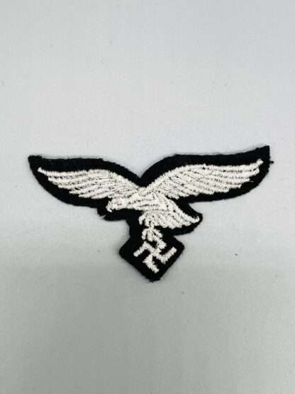 A reverse photo of A Luftwaffe Herman Göring Panzer-Division cap eagle,  machine embroidered eagle.