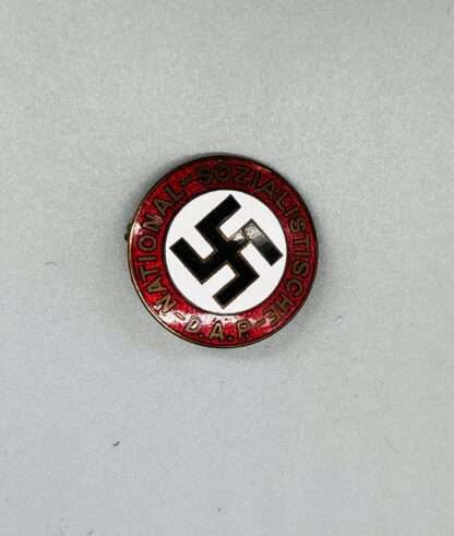 A NSDAP party badge, constructed in red, white, black, and gold enamel.