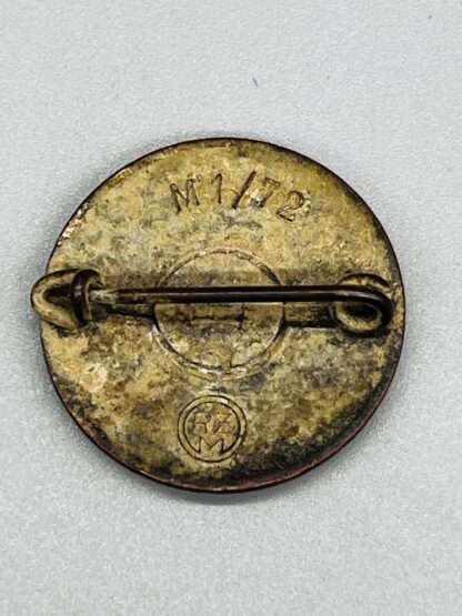 A reverse image of a late-war NSDAP Party Badge marked RZM M1/72 for Fritz Zimmermann, with horizontal safety pin.