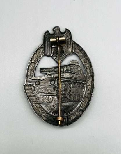 A photo of the reverse of a Panzer Assault Badge silver hollow back, zinc construction with crimped barrel hinge.