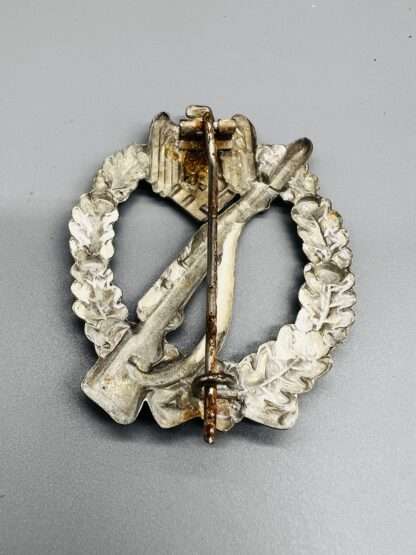 A reverse photo of WW2 German Infantry Assault Badge in Silver unmarked, hollow back.