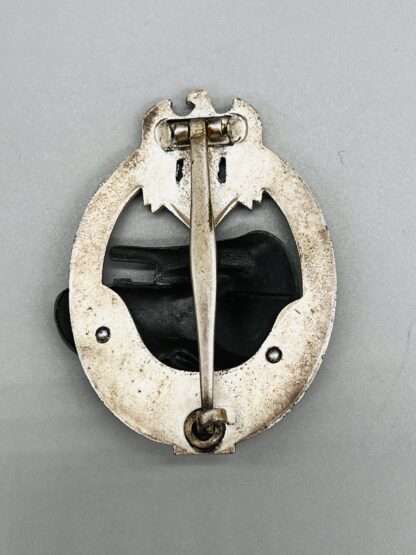A reverse photo of a WW2 German Panzer Assault Badge In Silver 25 By JFS, unmarked.