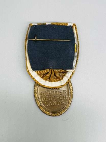 A reverse image of WW2 German West Wall Medal Court Mounted.