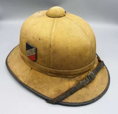 A WW2 German Heer Afrika Korp pith helmet with tan leather chin strap.