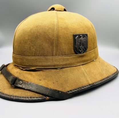 A WW2 German Heer Afrika Korp pith helmet with tan leather chin strap, with Heer shield.