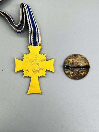 A revesre image of WW2 German Mother's Cross Gold and NSDAP Pin.