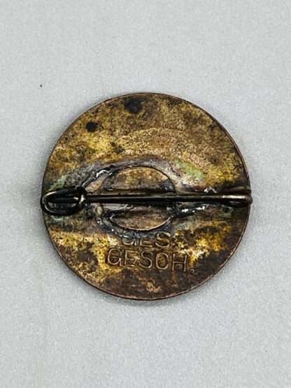 A revesre image of NSDAP Pin marked GES GESCH.