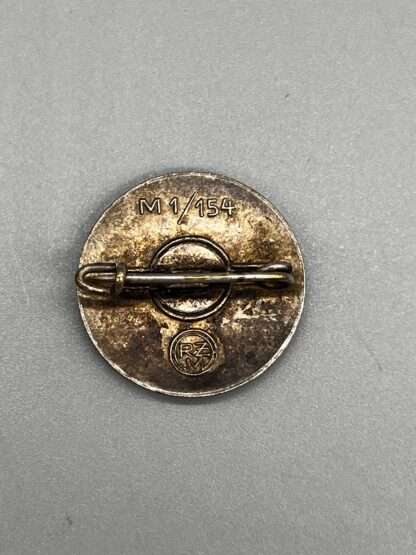 A reverse image of a NSDAP Party Badge Enamel Pin RZM M1/154 with horizontal pin.