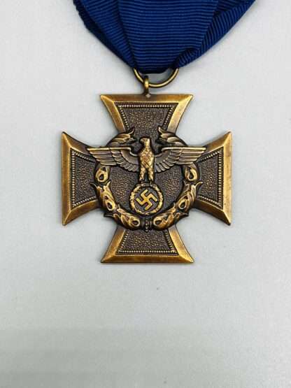 A close up image of a WW2 German Customs and Border Protection Long Service Medal, with orginal blue ribbon.