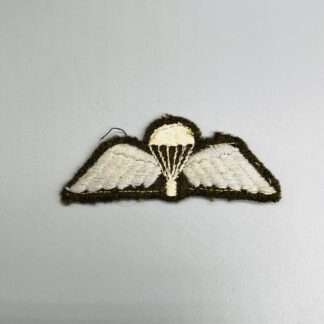 A British WW2 Paratrooper Jump Wings embroidered in white and blue thread on khaki green backing.