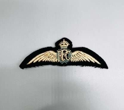 A WW1 Royal Flying Corp Pilot Wings, with blue wreath and RFC monogram flank by wings.