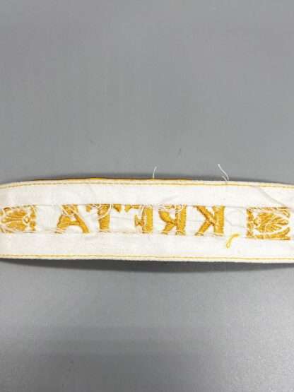 Reverse image of Kreta cuff title (Ärmelband) constructed in white cotton.