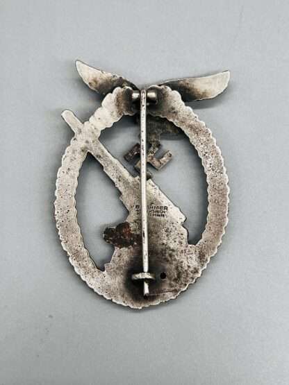 A photo of the reverse of a early WW2 Luftwaffe Flak Badge By Gustav Brehmer, constructed in tombac, with vertical pin.
