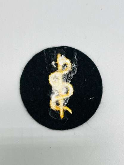 A revesre photo of a WW2 German Heer Medical trade badge.