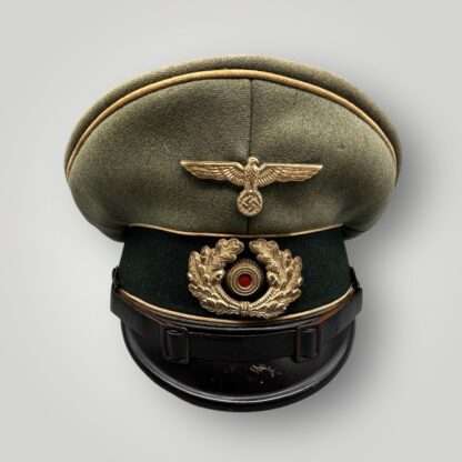 A WW2 German Heer infantry EM/NCO's visor cap, with green central band with wihite pipping and cupal insignia.