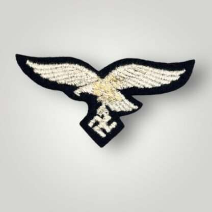 A reverse image of WW2 Luftwaffe EM/NCO's Herman Göring Panzer-Division breast eagle, machine embroidered with silver thread on black wool backing.