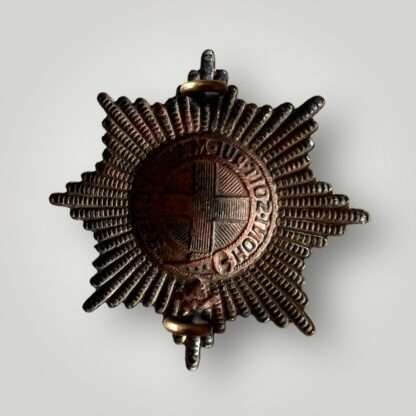 A reverse image of a brass Coldstream Guards WW2 cap badge.
