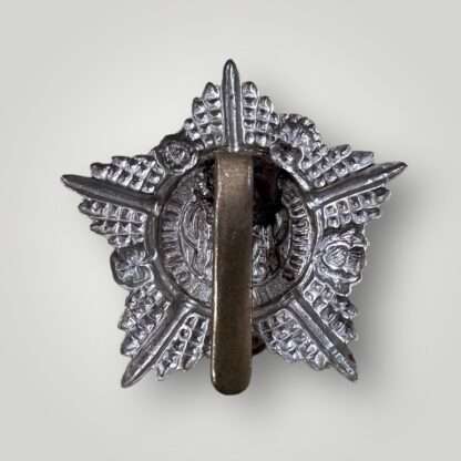 Reverse image of an original Guards Machine Gun Regiment WW1 cap badge, constructed in white metal with brass slider.
