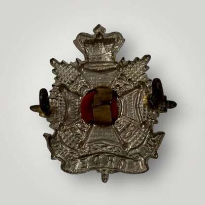 A reverse image of an original Border Regiment Victorian cap badge, constructed in white metal.