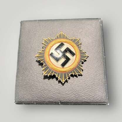 A WW2 German Cross in Gold by Zimmerman placed on top of the presentation case.