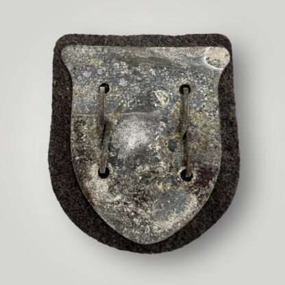 Reverse image of an Heer Kuban shield, complete with prongs, backing plate, and grey woollen backing.