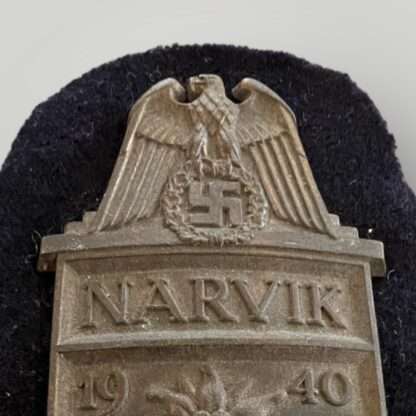 Close up of an Kriegsmarine Narvik Shield, with dark blue backing cloth.