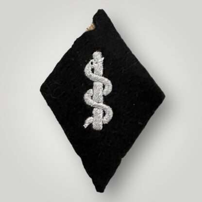 An SS medical services sleeve badge, costructed in silver bullion covered in black felt.