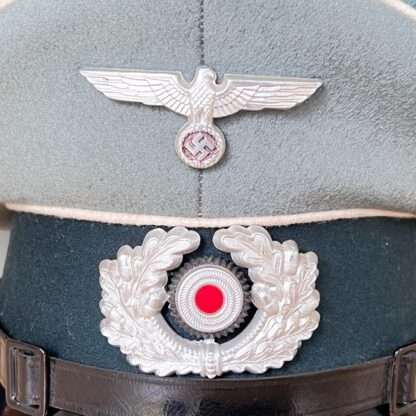 A WW2 German Heer EM/NCOs Infantry visor cap insigna, with white pipping and green band.