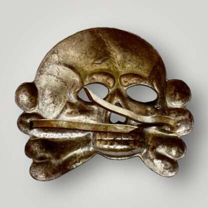 Reverse image of an original SS Skull 1st Pattern, constructed in tombak with prongs.
