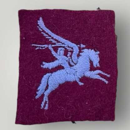 A WW2 British 1st Airborne formation patch, constructed in blue thread on maroon woolen backing.