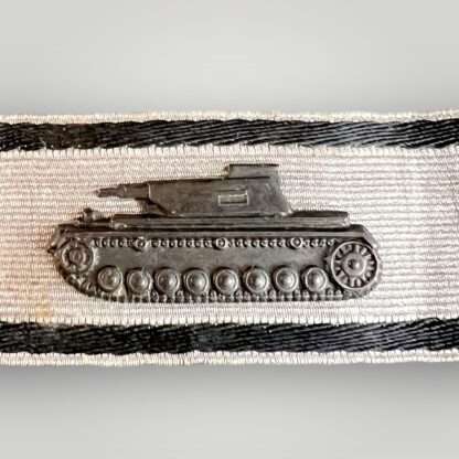 A WW2 German tank destruction badge in silver, contructed in blackened metal on silver aluminium bullion backing with two black strips of black thread above and below.