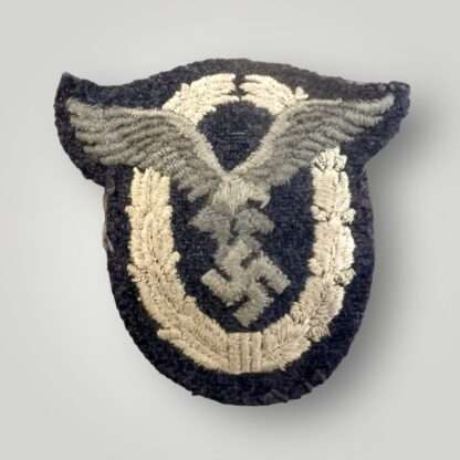 A Luftwaffe Pilots badge in cloth, machine embroidered in grey and silver thread on a dark grey woollen backing.