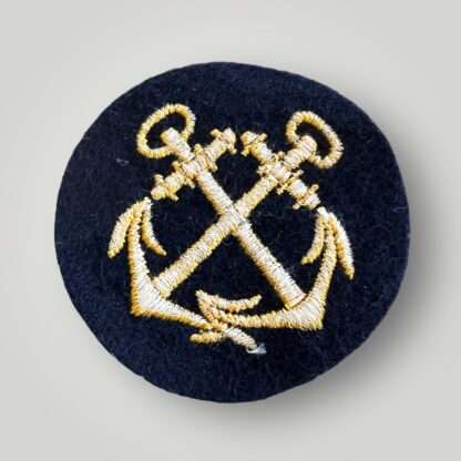 Reverse image of an original WW2 Kriegsmarine EM coxswain sleeve badge, machine embroidered with golden-yellow thread on dark blue wool backing.