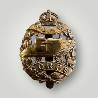 A British WW1 Royal Tank Corp Cap Badge in brass, which depicts a WW1 tank in the centre surrounded by a laurel wreath and King George V crown, complete with the inscription of the regiments motto "Fear Naught". 