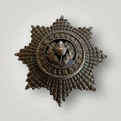 A Cheshire Regiment Officers cap badge post 1922, constructed in bronze with lovely patina. The obverse of the badge depicts an eight pointed star, in the centre is a circlet with the incription "The Cheshire Regiment".