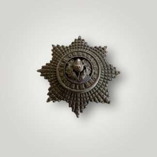A Cheshire Regiment Officers cap badge post 1922, constructed in bronze with lovely patina. The obverse of the badge depicts an eight pointed star, in the centre is a circlet with the incription "The Cheshire Regiment".