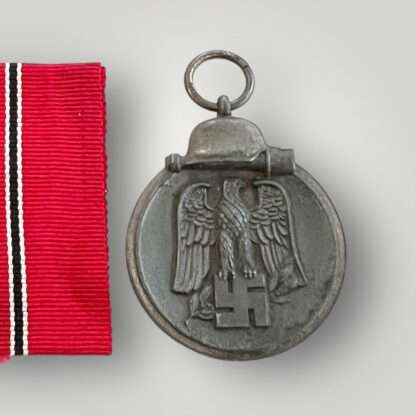 A German WW2 Eastern Front medal marked "127" on the medal ring attributed to the following manufacturer Moritz Hausch of Pforzheim, with original ribbon.